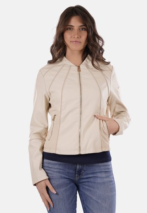 Giacca in pelle beige con zip frontale, cuciture oblique e tasche laterali. Presenta un colletto alto e un design aderente.