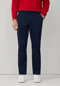 Pantalones ajustados azul marino con un diseño clásico, hechos de tejido de algodón suave, con bolsillos laterales y un estrechamiento gradual en el tobillo.