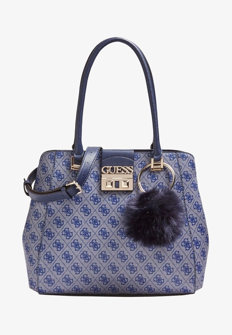 Sac à main Guess bleu et gris à motif, avec deux poignées, une bandoulière amovible, des accessoires dorés et un porte-clés pompon sombre et duveteux.