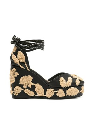 Sandalo zeppa nero con ricamo floreale marrone chiaro e cinturini da avvolgere alla caviglia, annodati a fiocco.
