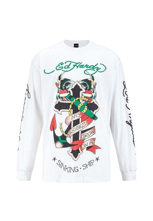 Camiseta blanca de manga larga con un gráfico central de un ancla negra con acentos coloridos y el texto "NO CRECEN ROSAS EN UN BARCO HUNDIDO" debajo.