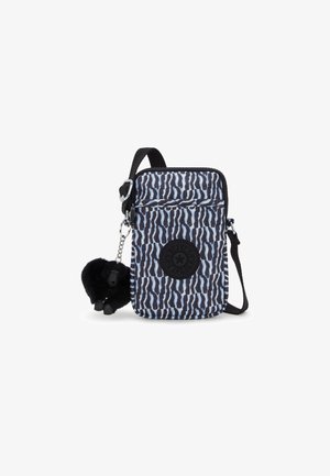 Patterned fabric bag in blue and black with a black logo. Features a detachable keychain pom-pom and an adjustable strap.