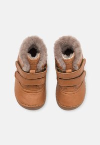 Hnědé kožené boty pro batolata s dvěma nastavitelnými pásky a měkkým šedým podšívkovým materiálem, s zaoblenou špičkou a prošívanými detaily na podrážce.