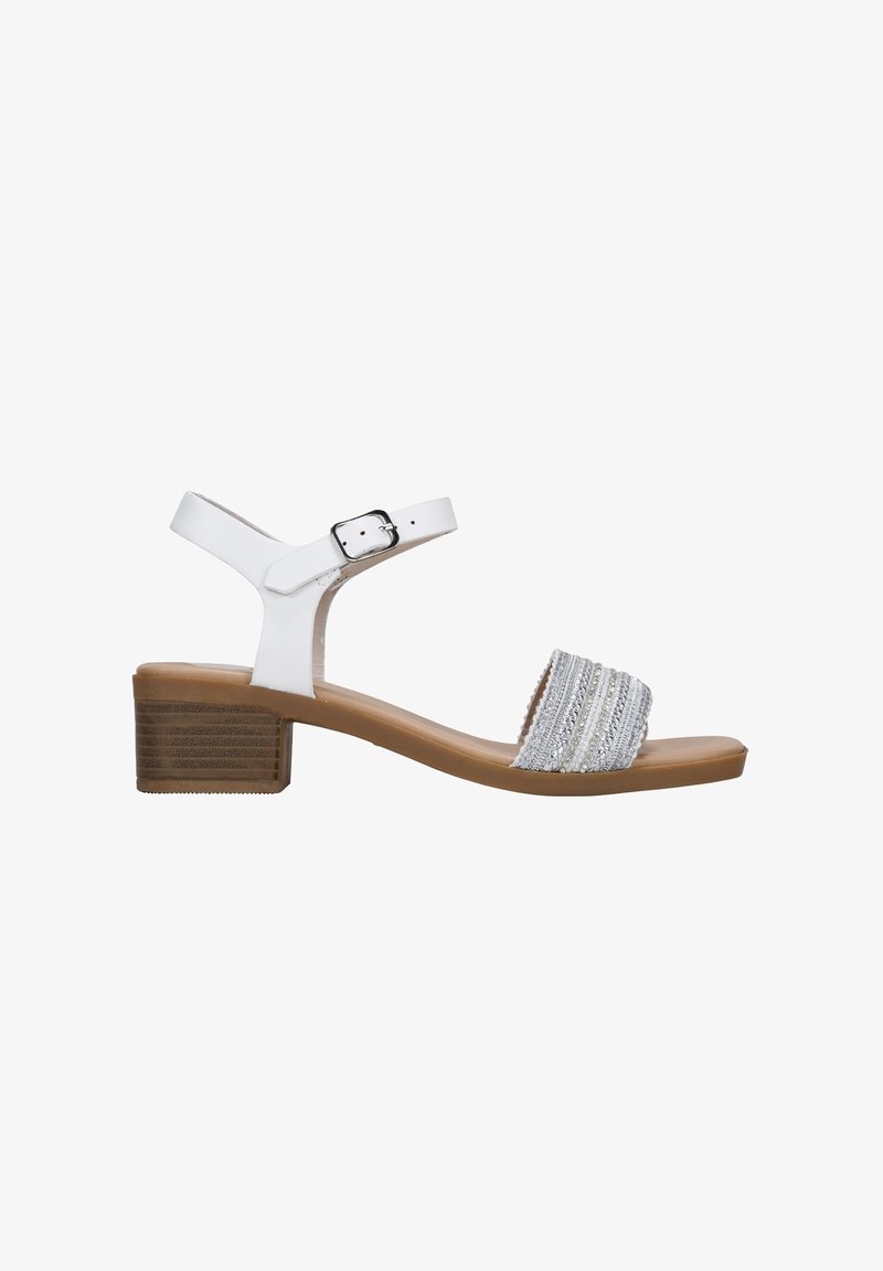 White heeled sandal with a textured silver strap and adjustable ankle buckle, featuring a tan block heel and smooth sole.