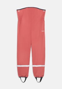 Waterdichte koraal overall met elastische taille, reflecterende witte strepen bij de enkels en verstelbare voetbanden. Merkenlogo gedrukt op de zijkant.