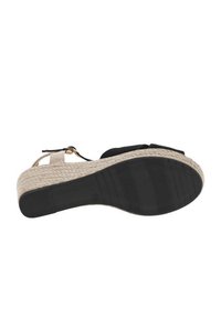 Black fabric wedge sandal with a textured jute platform and rubber outsole. Features an adjustable ankle strap for secure fit.