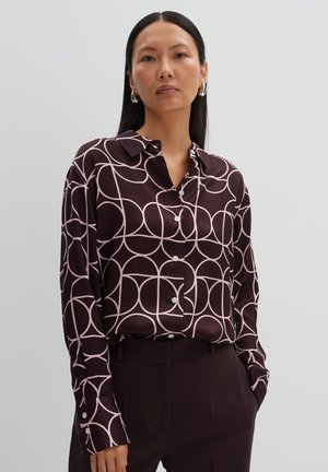 Dark brown button-up shirt with a pink geometric circle pattern, long sleeves, and a pointed collar. Smooth fabric with a glossy finish.