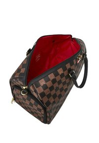 Bolsa de viaje de cuadros marrones con una abertura con cremallera, ribete negro, forro interior rojo y detalles en dorado.