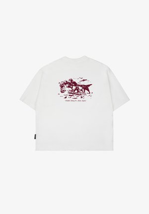 Valge puuvillane T-särk, mille seljal on marooni värvi loomade maastikukujundus, lühikesed varrukad ja vabalt asetsev lõige.