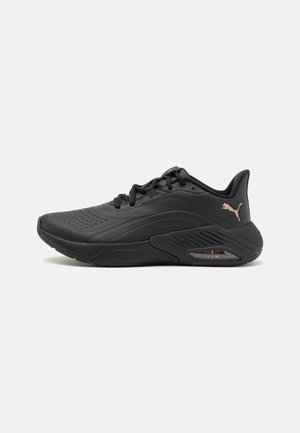 Sort atletiksneaker med snørebånd foran, tyk polstret sål og pink Puma-logo på hælen, vist fra den ydre side.