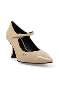 Scarpa Mary Jane in vernice beige con tacco alto, punta affusolata, perforazioni decorative e cinturino con fibbia dorata sul collo del piede.
