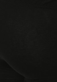 Leggings neri realizzati in un materiale liscio ed elasticizzato. Presentano una vestibilità aderente con una vita alta e una leggera texture.