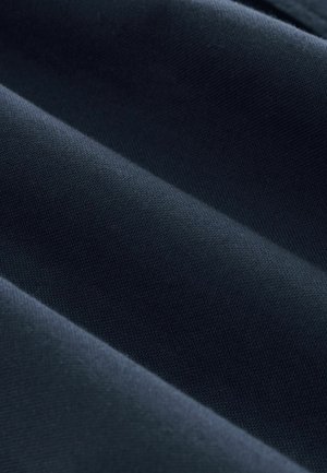 Mørkeblå stof med en tekstureret overflade, præget af glatte folder og et ensartet vævemønster, der reflekterer lys i subtile nuancer.