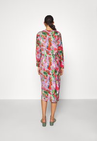 Langärmliges Kleid mit Blumenmuster in Pink-, Grün- und Rottönen, mit einer taillierten Silhouette und knielangem Saum. Der Stoff sieht weich aus.