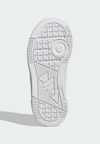 Suela de goma blanca para zapatilla deportiva con patrones de agarre texturizados, detalle de logo circular y elementos de diseño angulares para una tracción mejorada.