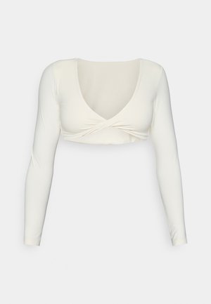 White long-sleeve crop top with a deep V-neckline and twisted front design, made from a smooth, stretchy fabric.