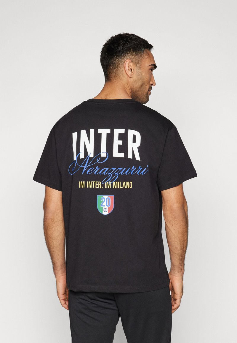 Svart t-skjorte med hvit og blå tekst "INTER" og "Nerazzurri" på baksiden, med et grønt, hvitt og rødt emblem under.