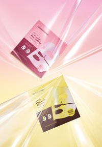 Dwa pudełka maseczek na twarz: różowe "Collagen Light Up" i żółte "Collagen Glow Up." Oba mają minimalistyczny design z ikonograficznymi grafikami.