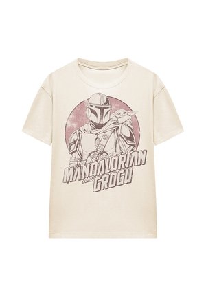 Beige t-shirt featuring printed graphic of Mandalorian in armor with Grogu on his shoulder inside a circular background.