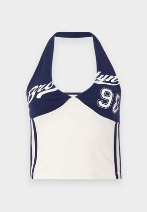Námornícky modrý a krémový bavlnený crop top s halter výstrihom, s potlačou "Brooklyn" a číslom 98. Hladká textúra, športový dizajn a farebné blokovanie.