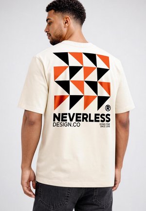 Man wearing beige t-shirt with black and orange geometric triangles and "NEVERLESS DESIGN.CO" text on the back, facing away from the camera.