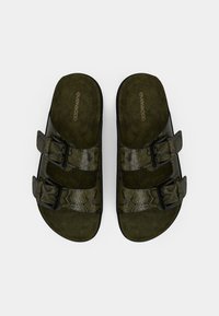 Πράσινα σανδάλια τύπου σλάιντ με υφή φιδίσιο δέρμα, δύο ρυθμιζόμενους ιμάντες με μαύρες πόρπες και σουέντ πάτο.