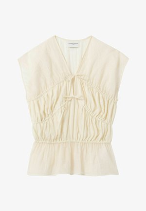 Blusa ligera color crema con mangas cortas tipo capa, escote en V, dos cierres delanteros con lazo, cintura fruncida y dobladillo ligeramente acampanado.