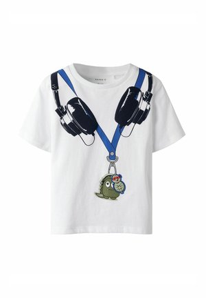 Camiseta blanca para niños con auriculares negros impresos en un cordón azul y llaveros de dibujos animados de dinosaurio y tortuga colgando de él.