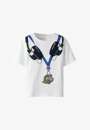 Camiseta blanca para niños con auriculares negros impresos en un cordón azul y llaveros de dibujos animados de dinosaurio y tortuga colgando de él.