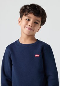 Felpa blu navy in tessuto morbido con scollatura rotonda, maniche inserite e un piccolo logo rosso di Levi's sul petto.