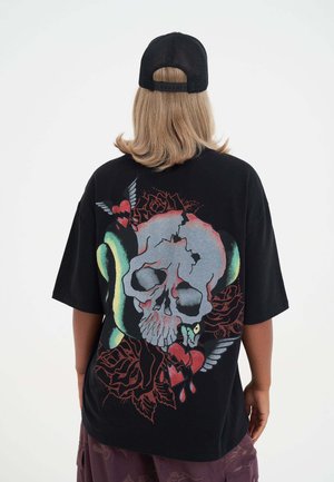 Schwarzes, oversized T-Shirt mit einem großen, bunten Totenschädel-Graphic, umgeben von Rosen, einer Schlange und Herzen. Weiches Material und kurze Ärmel.