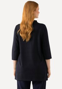 Navyblaue Tunika mit 3/4-Ärmeln, geradem Schnitt und glatter Textur. Das Kleidungsstück verfügt über einen runden Ausschnitt und seitliche Schlitze.