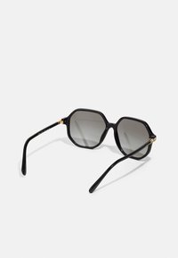 Ochelari de soare octagonali negri cu lentile gri degradate. Cadru din plastic lucios cu accente aurii la balamale. Design elegant și modern.
