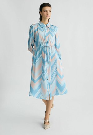 Hellblaues, langärmeliges Kleid mit einem Chevron-Muster in Blau- und Pfirsichtönen; durchgehende Knopfleiste, Kragen und Kordelzug in der Taille.
