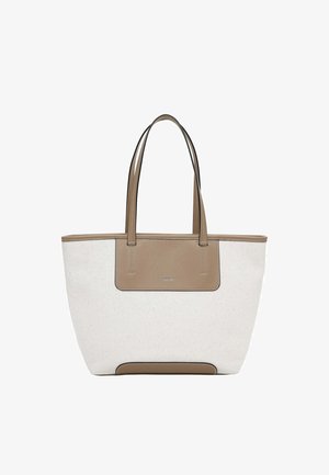 Sac fourre-tout en toile beige et blanche avec deux longues poignées en cuir beige, une pièce de cuir à l'avant et un petit logo de marque argenté.