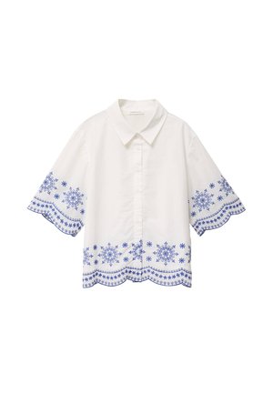 Hvid bluse med korte ærmer og blå blomsterbroderi langs ærmer og kant, med klassisk krave og knaplukning foran.