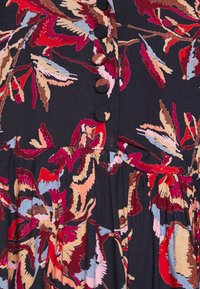 Schwarzer Stoff mit roten, rosa und blauen Blumenmustern, mit einem Knopfverschluss und gerafften Rockdetails.