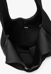 Svart tote-väska i neopren med en slät yta, breda remmar och en meshficka inuti med en logotags högst upp.