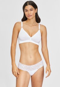 White cotton bralette with soft cup, adjustable straps, and a lace-trimmed white panty featuring floral pattern on the waistband.