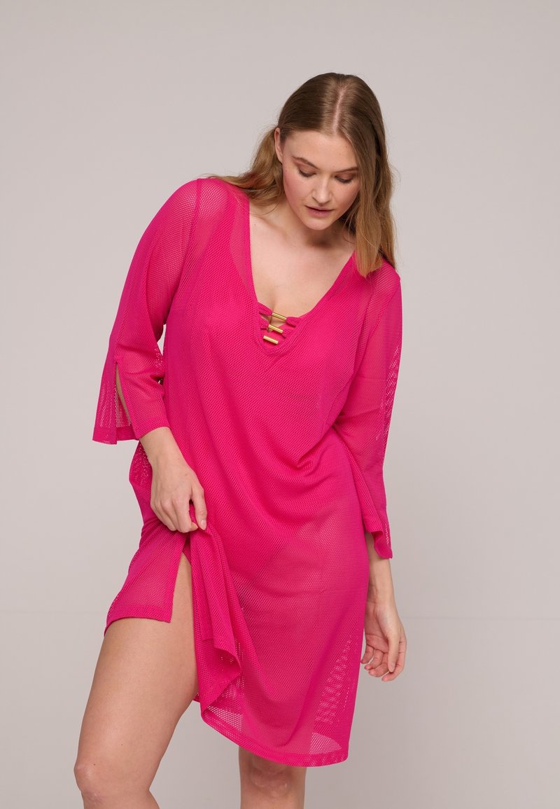Roze mesh cover-up jurk met een V-hals, driekwart mouwen en decoratieve gouden accenten op de halslijn. Split aan de zijkant.