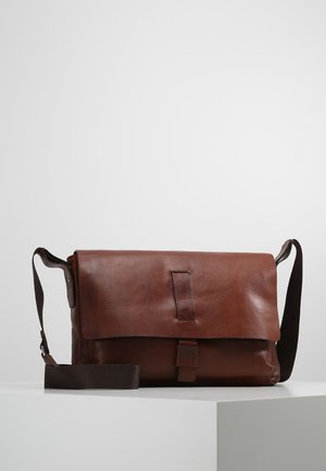Brown leather messenger bag with a flap closure, adjustable fabric strap, and minimalist design, featuring smooth texture and subtle detailing.