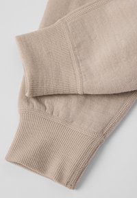 Beige katoenen sweatshirtmanchetten met ribbeltextuur en vlakke naden, met een zachte afwerking en gladde randen voor comfortabel dragen.