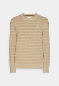 Beige gestreifter Pullover aus Strickstoff, mit Rundhalsausschnitt und gerippten Bündchen, sowie einem kleinen Logopatch auf der Brust.