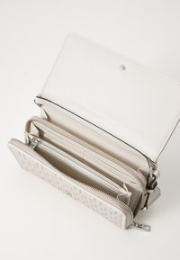 Beige textured wallet with a grid pattern, multiple compartments, zip closure, and a snap button. Smooth leather and silver-tone hardware.
