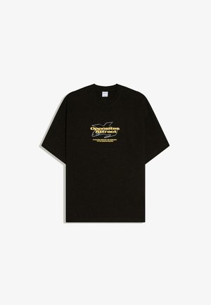 Black short-sleeve T-shirt with yellow text "Opposites Attract" and smaller white text over abstract white line art on the chest.