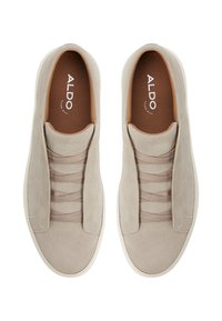 Beżowe zamszowe sneakersy typu slip-on z elastycznymi detalami, jasnobrązowymi wkładkami i białymi gumowymi podeszwami. Prosty design o gładkiej teksturze.