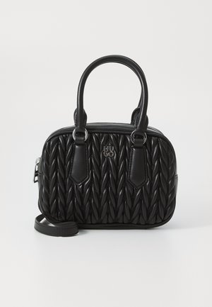 Bolso negro hecho de cuero acolchado con forma redondeada, dos asas superiores y una correa desmontable. Presenta un detalle de logotipo en la parte frontal.
