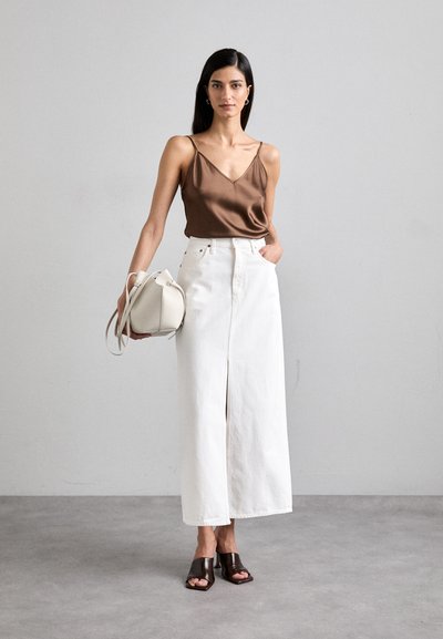 Brown satin tank top, white denim maxi skirt with front slit, brown open-toed shoes, and a small white handbag. Smooth texture throughout.