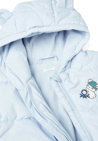 Světle modrá naducaná bunda s fleecovou podšívkou, s kapucí se ušima, zipovým uzavřením a vyšitým medvědím motivem na hrudi.