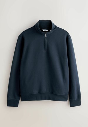 Dunkelblaues Sweatshirt mit einem halben Reißverschlusskragen, langen Ärmeln, gerippten Bündchen und glatter Textur, entworfen für Komfort und Wärme.